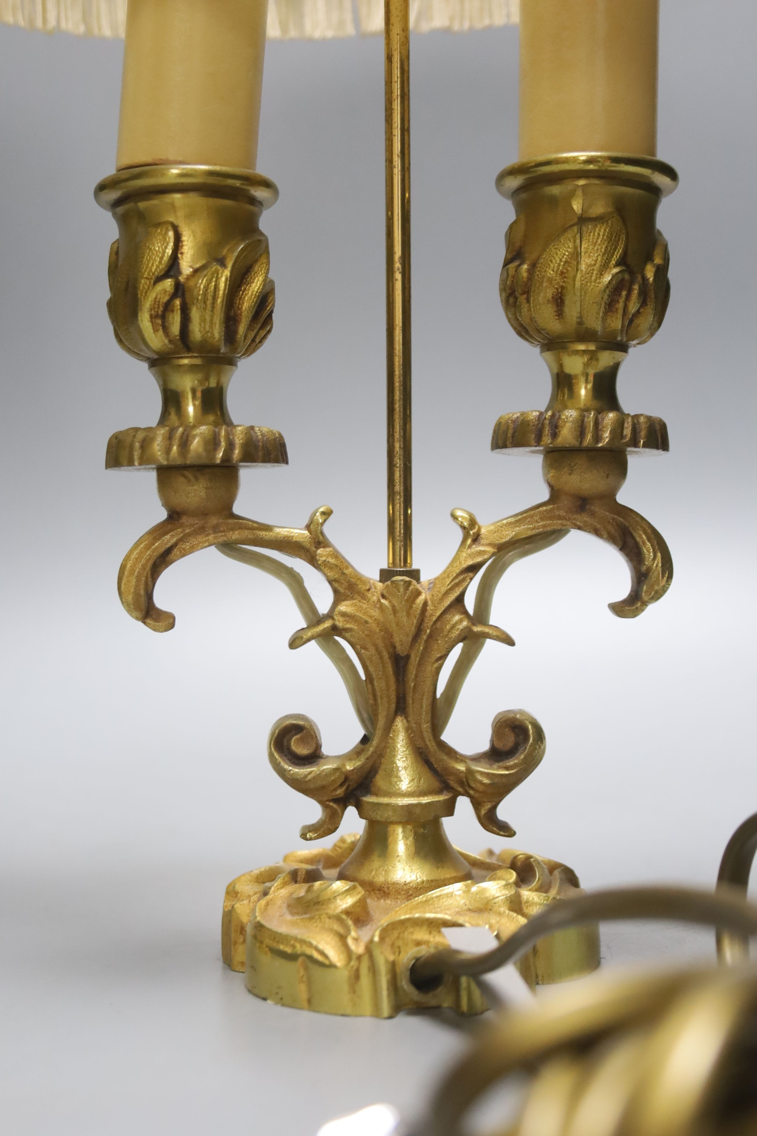 A pair of 19th century brass three branch candlesticks and a pair of twin branch table lamps, tallest 40cm